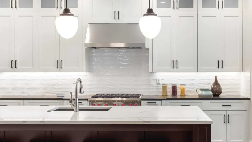 Glossy white tile backsplash under cabinet lighting